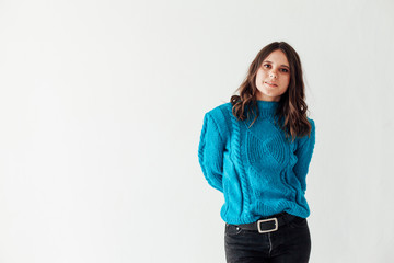 Portrait of a beautiful young fashionable brunette brunette woman in a blue sweater