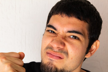 portrait of a young Hispanic man threatening with his fist