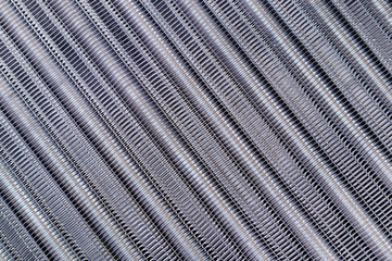 Tubes of cooling radiator as background. Top view. Bank of cells and aluminum tubes in which circulating fluid cooled by surrounding air.