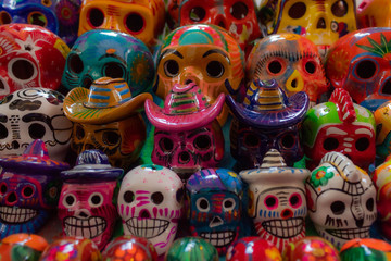 Fototapeta na wymiar Colorful Mexican skulls for day of the dead. Cancun souvenir market has a wide array of talavera skulls, aka catrinas for Mexican Halloween