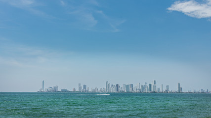 View from the distance of a coastal town surrounded by a turquoise blue sea