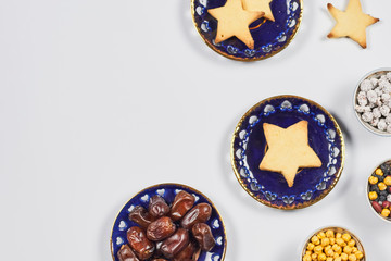 Iftar foods on white table. Traditional middle-eastern lunch with cookies and dry date fruits