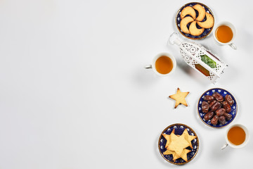 Iftar foods on white table. Traditional middle-eastern lunch with cookies and sweets