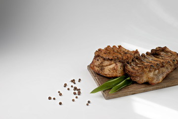 the ribs baked in the oven are placed on a wooden Board with ramson and allspice. baked meat for the holiday table. barbecue ribs for restaurant menu