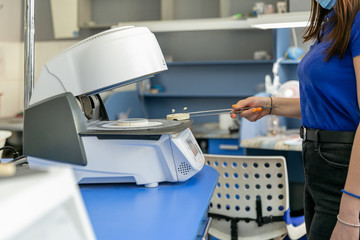Denture layout. Technician takes ready-made tooth models from the oven. Dental laboratory, implantation