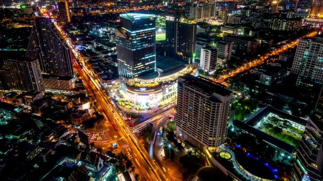 Bangkok business district city center above Samyan area and traffic, with buildings and skyscrapers, during night, tilt down � Time Lapse