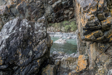 Rock cliff opening to beach in background