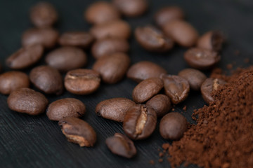 Detalle de granos de café y café molido, sobre base de madera obscura
