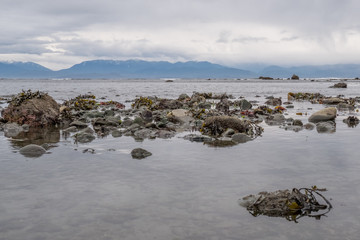 Tidal waters beach on Vancouver Island BC Canada looking Olympic Peninsula