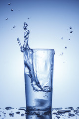 A splash of water in a glass in blue
