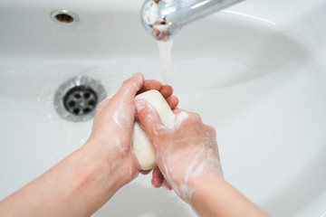 Hand washing with soap. Girl washes her hands with antibacterial soap for the prevention of...