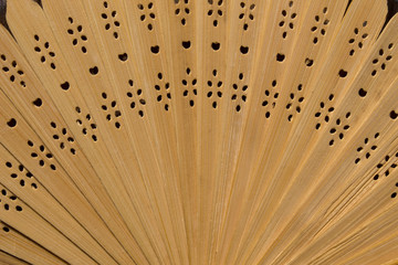 Folding wooden fan, disclosed. Light background, close-up. Asian traditions, china and japan. Wood and lace.