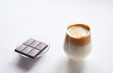 Cold coffee cream with cold Dalgon milk. Trend. In a transparent glass on a white background.