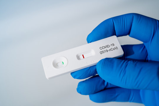 Doctor holding a Negative Result for COVID-19 with test kit for viral disease COVID-19 2019-nCoV. Lab card kit test for coronavirus SARS-CoV-2 virus. Fast test COVID-19.