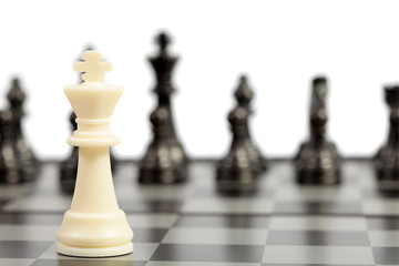 Chess pieces on the chessboard on white background. Closeup of some chess figures