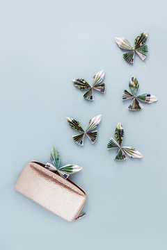Money flies out of the wallet on a blue background. The concept of financial crisis and poverty. Selective focus