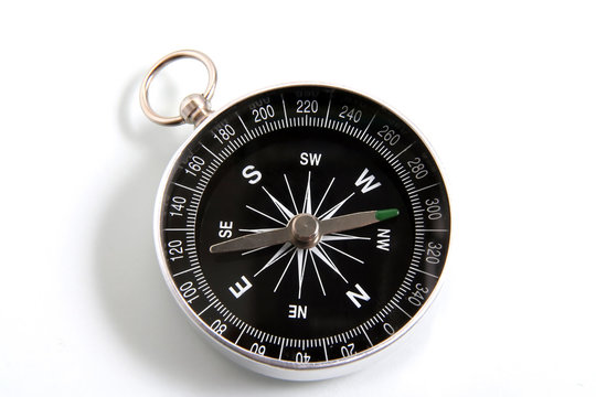 Closeup compass isolated on a white background. Travel geography navigation modern compass