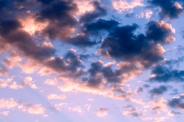 Dark and pink clouds in blue sky at sunset 
