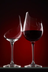 broken wine glass with wine on a dark red background