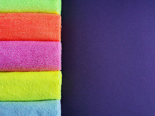 
colored microfiber towels on a dark purple background. Close-up. terry napkins.