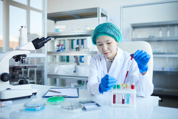 Female doctor working at her workplace she making test with blood samples at office