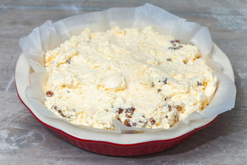 raw curd dough in a round ceramic baking dish