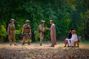 Muslim man shake hand with soldier man and his family stay near to him with concept of cooperate people during war.
