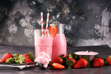 Glass of fresh strawberry shake, smoothie or milkshake and fresh strawberries on table. Healthy food and drink concept