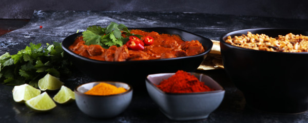 Chicken tikka masala spicy curry meat food in pot with rice and naan bread. indian food on table