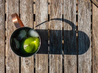 cold beverage with limes in copper mug
