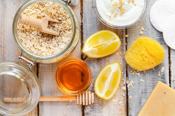 Concept of natural organic ingredients in cosmetology and gentle home treatment during quarantine. Do it yourselft. Handmade mask with honey, yogurt, oats, lemon. Wooden background. Flat lay top view 