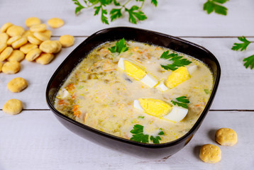 Creamy chicken soup with egg and crackers.