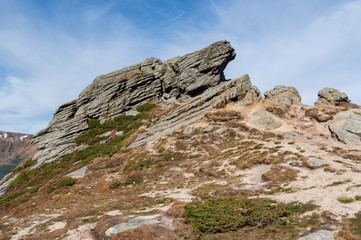 Large rocky stone against the sky. Big stone on the top of the mountain.