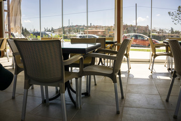 Empty chairs and tables in a cafe. The cafeteria restaurant ready for sunny weekend customers. Resort cafe for eating or drinking.