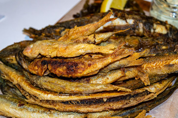 Fried small fish on wooden board