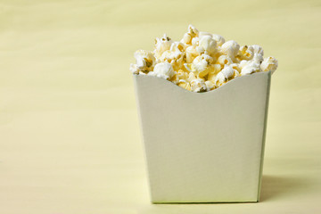 popcorn in the yellow bowl on blue background with space for text.typical brazilian june party