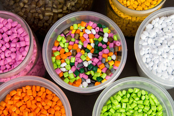 Plastic pellets. Dyes for plastic, polypropylene, polyethylene. Plastic granules in a measuring container and test tubes in the laboratory.