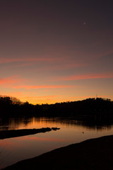 Paisaje de sierras y laguna al atardecer.