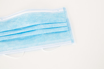 Close up of a Blue Disposable Medical Face Mask on a White Background. Coronavirus concept