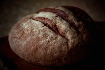 round bread, lying on a brown, wooden Board
