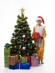 A girl stands with a red gift near the Christmas tree