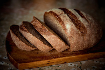 round bread, lying on a brown, wooden Board
