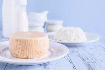 Young cheese close-up. In the background a set of dairy products. Photo in light blue tones with...