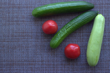 
Cucumbers and red tomatoes on the kitchen table. View from above