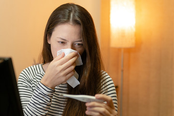 Model sounding nose and looking on the thermometer at her workplace. People Feeling Sick Concept.