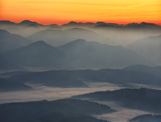 Plakat silhouettes of foggy mountains. picturesque mountain peaks at sunrise.