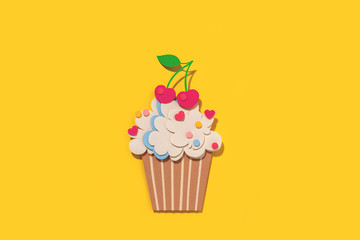 Paper cutting cupcake on yellow background. Handmade art work. Colorful sprinkles, dot and star, for your birthday card design. 