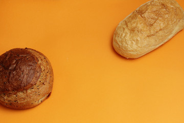 fresh bread with flax and ciabata on an orange background