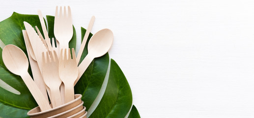 banner eco friendly disposable kitchenware utensils on white background. wooden forks and spoons in paper cup. ecology, zero waste concept. copyspace.