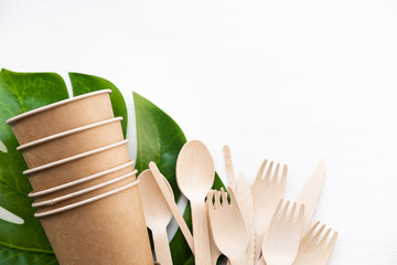 eco friendly disposable kitchenware utensils on white background. wooden forks and spoons in paper cup. ecology, zero waste concept. top view. flat lay.
